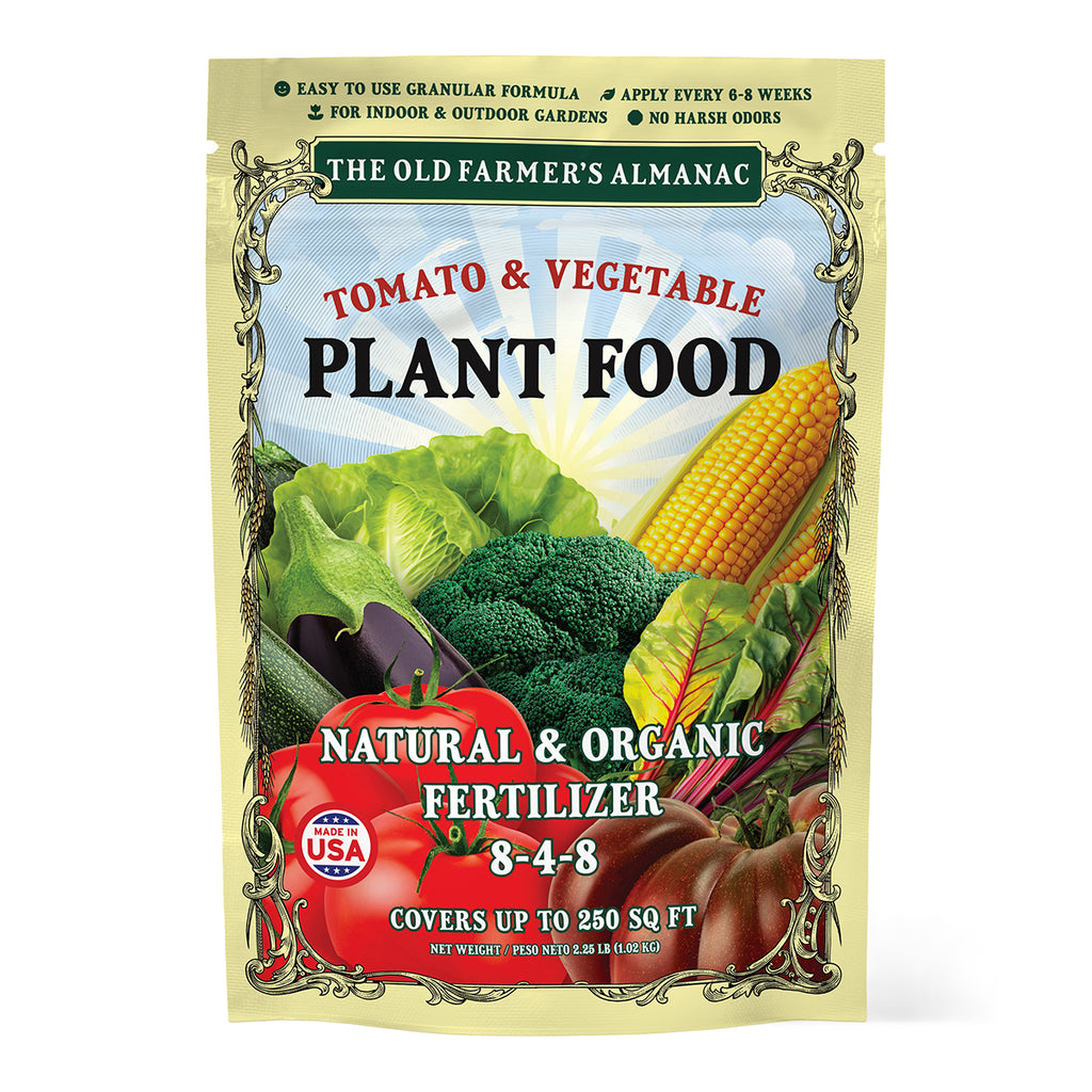 Package of tomato and vegetable plant food with vegetables on a white background