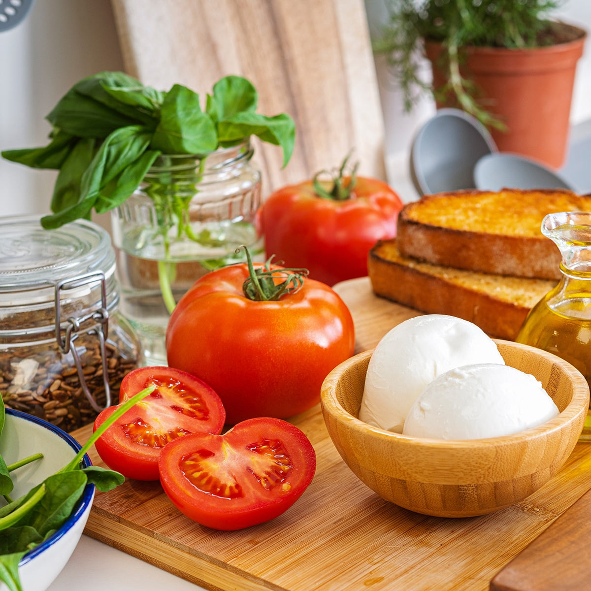 Tomatoes on a cutting board with Mozzarella cheese and basil 