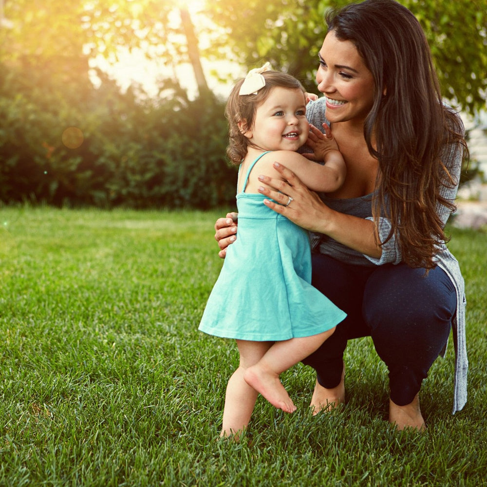 Woman and child standing on lawn barefoot 